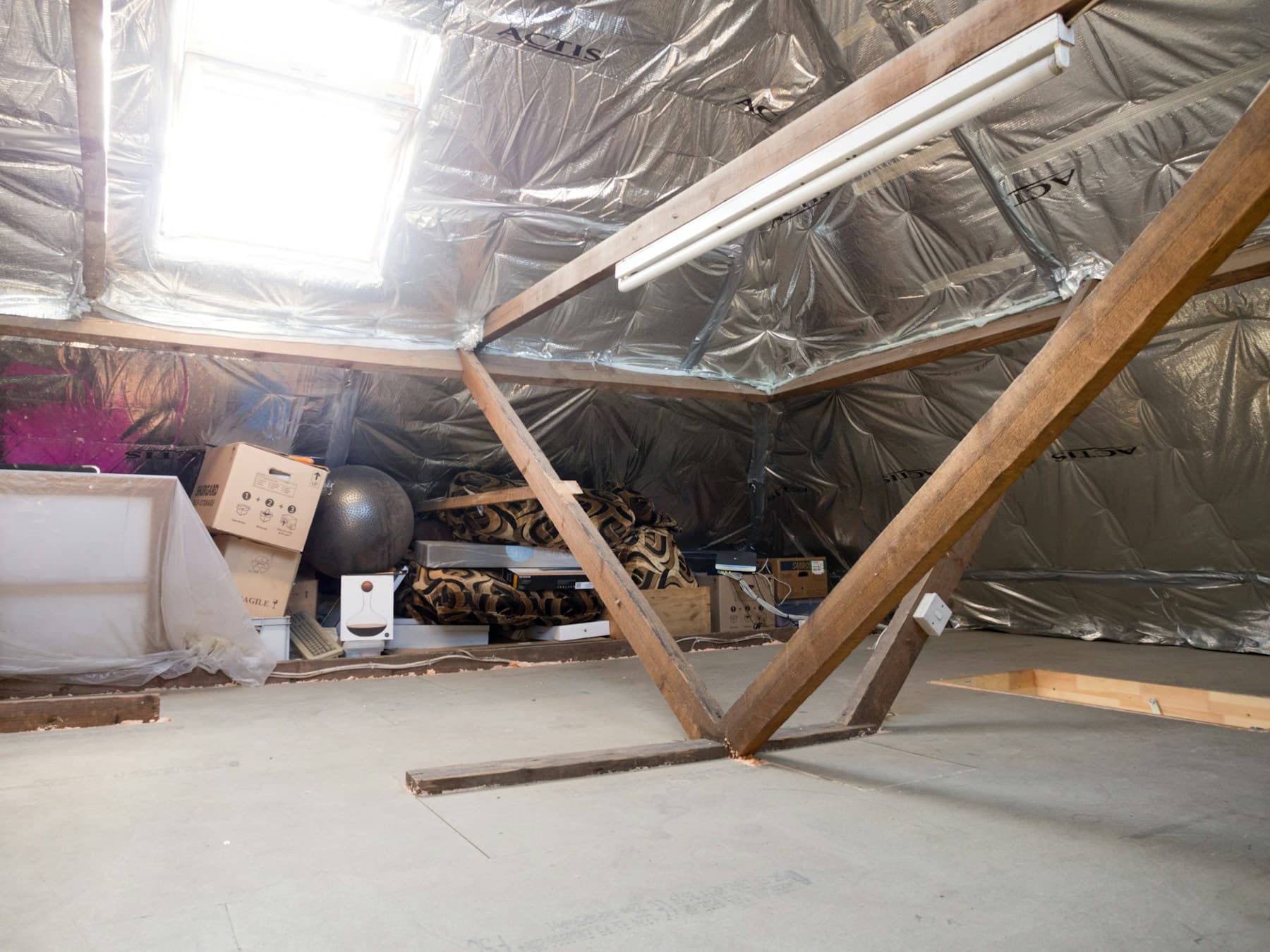 Ungenutztes Dachgeschoss mit sichtbaren Holzbalken und gedämmter Dachfläche