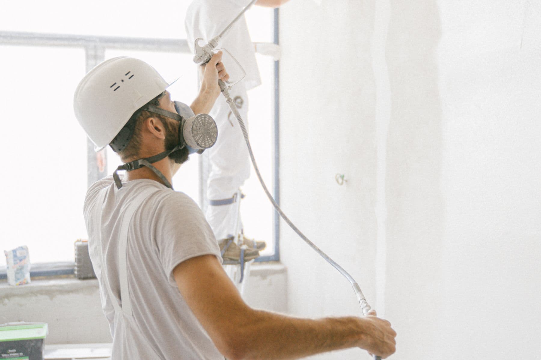 Gleichmäßiger weißer Farbauftrag mit dem Spritzgerät auf einer Innenwand